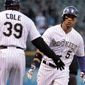 Colorado Rockies third base coach Stu Cole (39) congratulates Rockies&#x27; Carlos Gonzalez (5) after Gonzalez&#x27;s home run in the first inning of a baseball game against the New York Mets in Denver, Thursday, May 1, 2014.(AP Photo/Joe Mahoney)