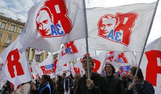 Members of pro-Kremlin movement Young Guard carry flags depicting Russian President Vladimir Putin during a May Day rally in St. Petersburg, Russia, Thursday May 1, 2014. The flag reads: &#39;I Support!&#39;. (AP Photo/Dmitry Lovetsky)