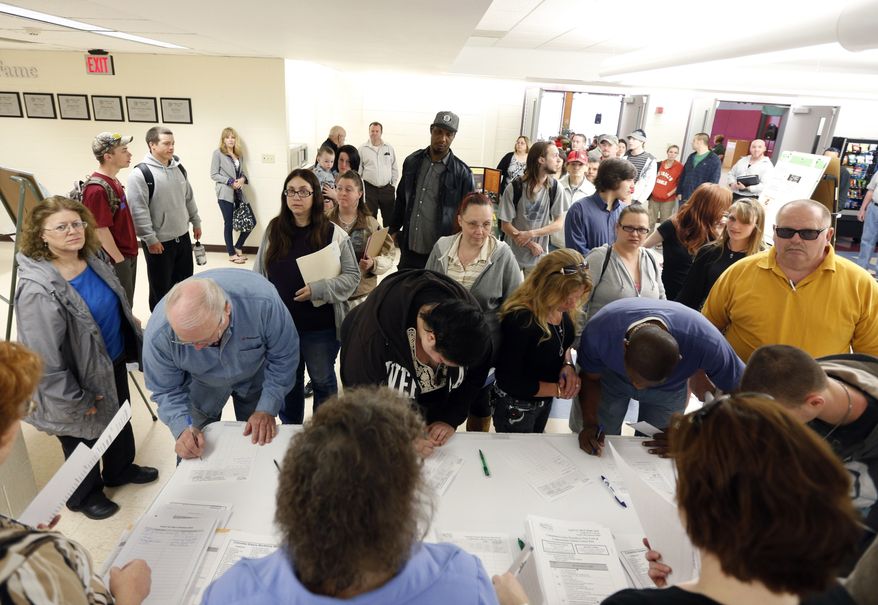 In this April 22, 2014, photo, job seekers line up for a job fair at Columbia-Greene Community College in Hudson, N.Y. (AP Photo/Mike Groll)