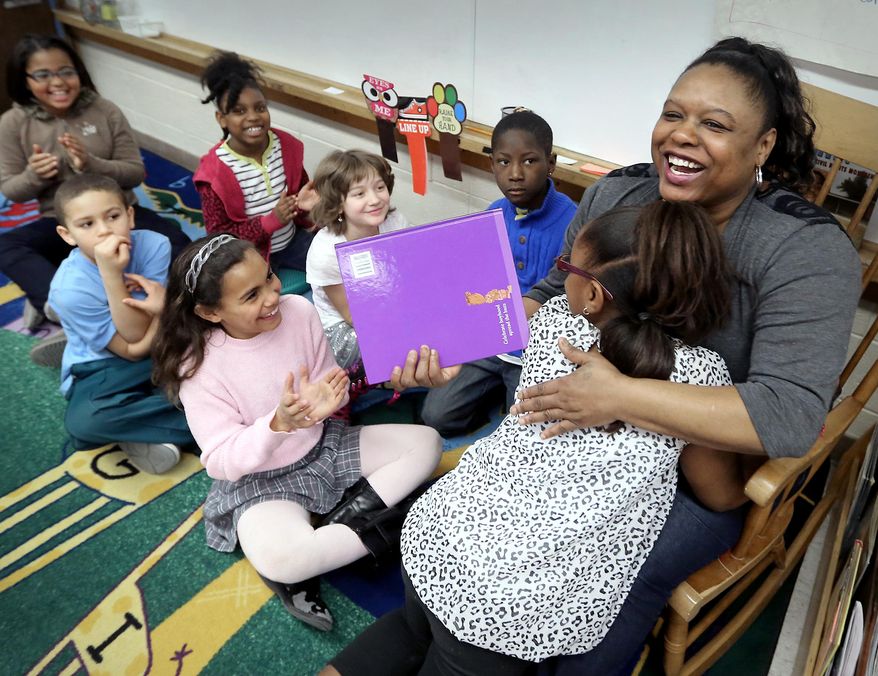 Quanta Smith is embraced by her daughter, Kia, 9, following a reading session inside her daughter's third grade classroom at Mendota Elementary School in Madison, Wis. Friday, March 28, 2014. The Madison School District is opening its schools to students' parents as a way to engage families. (AP Photo/Wisconsin State Journal, John Hart)