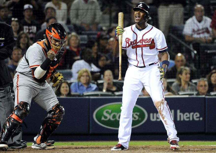 San Francisco Giants catcher Hector Sanchez, left, clenches his fist as Atlanta Braves' Justin Upton, right, strikes out to end the ninth inning of a baseball game Friday, May 2, 2014, in Atlanta. San Francisco won 2-1. (AP Photo/David Tulis)