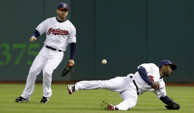 Cleveland Indians&#x27; Michael Bourn, right, dives for but cannot catch a single hit by Chicago White Sox&#x27;s Alexei Ramirez in the fourth inning of a baseball game on Friday, May 2, 2014, in Cleveland. Indians&#x27; Ryan Raburn, left, watches. (AP Photo/Tony Dejak)