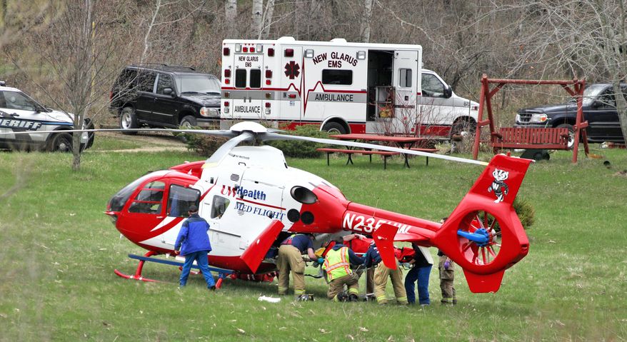 Emergency personnel place one of two Dane County sheriff's deputies that were stabbed in the leg during an incident in the town of Primrose, north of New Glarus, Wis., into a medical helicopter Thursday, May 1, 2014. An unnamed third deputy fatally shot the man who stabbed Lt. Brian Hayes and Deputy Roger Finch. The two stabbed deputies were airlifted to UW Hospital with non life-threatening injuries. (AP Photo/The Monroe Times, Anthony Wahl)