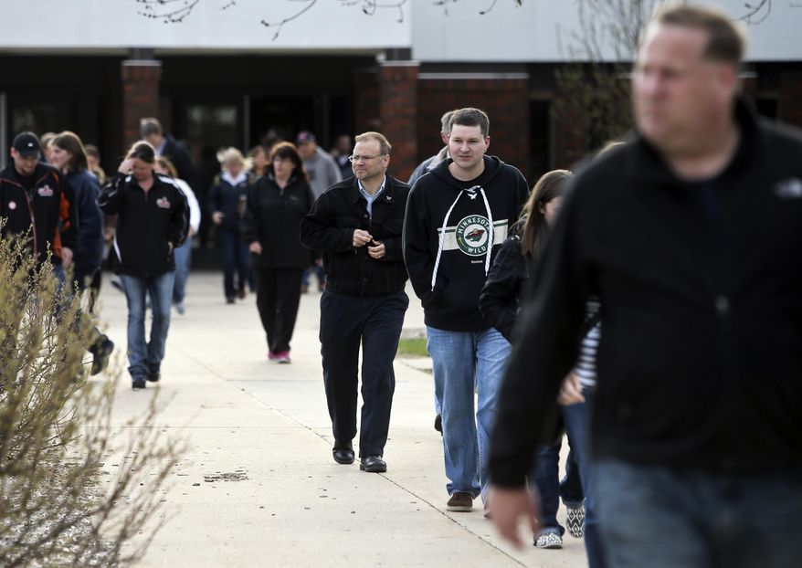 Parents and children walk out of Waseca High School, on Friday, May, 2, 2014, in Waseca, Minn. A plot b ya 17 year-old Waseca High student to kill his family and to massacre students in Waseca was uncovered and foiled on Thursday. (AP Photo/The Star Tribune, David Joles) MANDATORY CREDIT; ST. PAUL PIONEER PRESS OUT; MAGS OUT; TWIN CITIES TV OUT