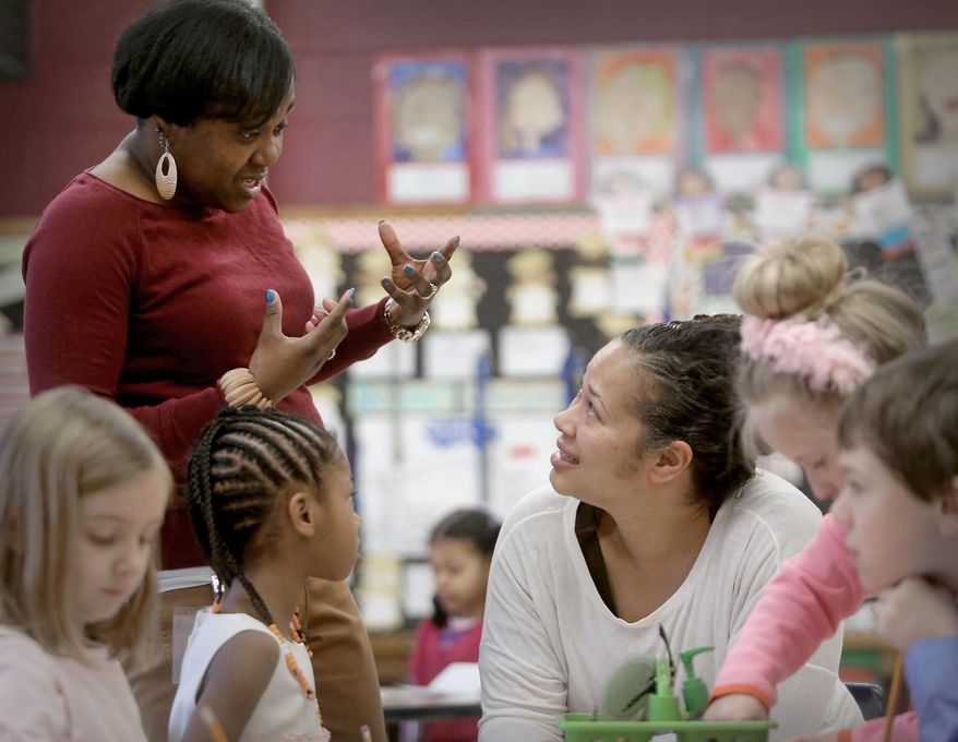 Mendota Elementary School parent liaison Sonia Spencer, left, converses with Elise Butterfield during Butterfield's visit to her daughter's first grade class at the Madison, Wis. school Friday, March 28, 2014. The Madison School District is opening its schools to students' parents as a way to engage families. (AP Photo/Wisconsin State Journal, John Hart)