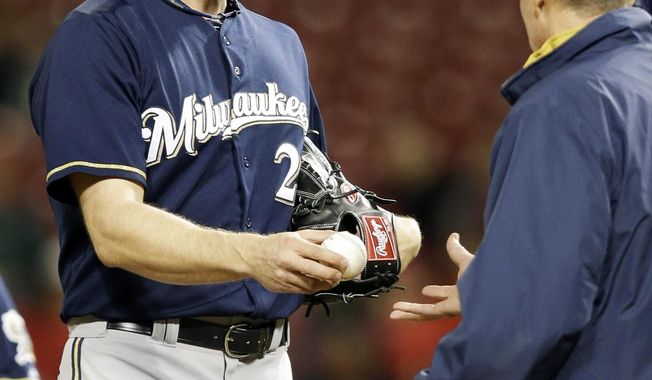 Milwaukee Brewers relief pitcher Jim Henderson, left, is taken out by manager Ron Roenicke in the eighth inning of a baseball game against the Cincinnati Reds, Thursday, May 1, 2014, in Cincinnati. Henderson was the losing pitcher in the game won by Cincinnati 8-3. (AP Photo/Al Behrman)