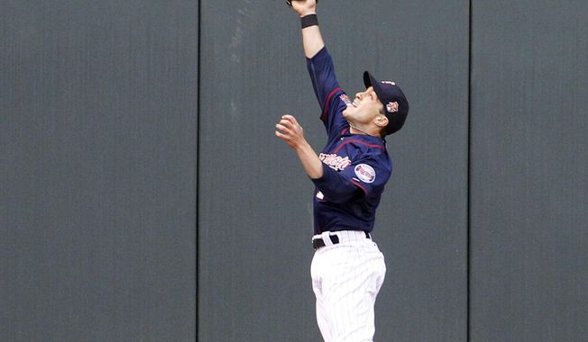 Minnesota Twins center fielder Sam Fuld (1) makes a leaping catch on a fly to center by Baltimore Orioles&#x27; Manny Machado during the first inning of a baseball game in Minneapolis, Friday, May 2, 2014. (AP Photo/Ann Heisenfelt)