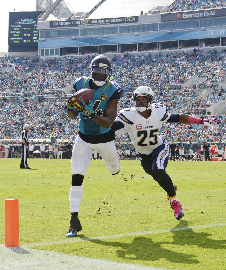 FILE - In this Oct. 20, 2013, file photo, Jacksonville Jaguars wide receiver Justin Blackmon, left, makes a catch but can't stay in bounds to score a touchdown as San Diego Chargers defensive back Darrell Stuckey defends during the second half of an NFL football game in Jacksonville, Fla. The Jaguars expect to be without their suspended receiver all season, maybe even longer. General manager Dave Caldwell said Friday, May 2, 2014, it would be “relatively surprising” to have Blackmon back on the field this fall. Blackmon is suspended indefinitely without pay for repeated violations of the league’s substance-abuse policy.(AP Photo/Phelan M. Ebenhack, File)