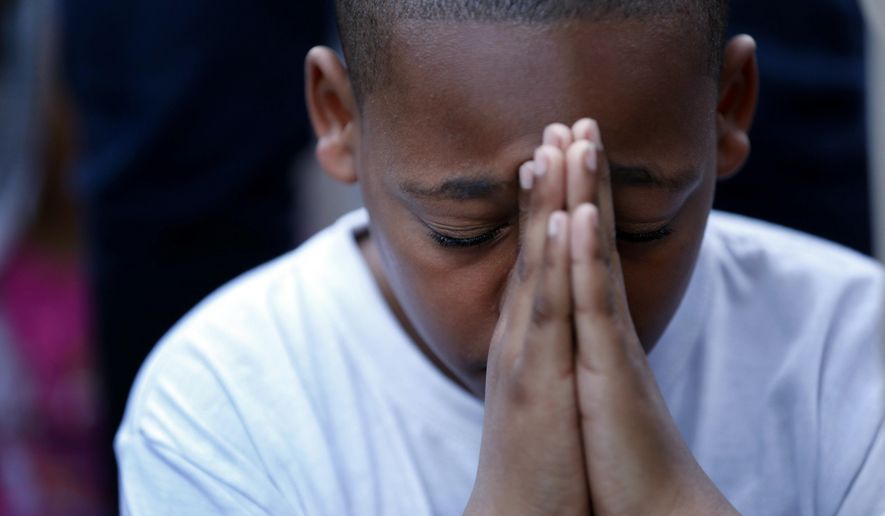 A young boy folds his hands in prayer during a prayer vigil for Martin Cobb at Abundant Life Church on Richmond's south side Saturday, May 3, 2014. A 16-year-old boy was charged Saturday in the assault of a young girl and the killing of Martin, her brother, who was apparently slain when he tried to protect her, authorities and relatives said. (AP Photo/Richmond Times-Dispatch, Dean Hoffmeyer)
