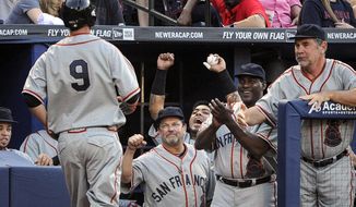 San Francisco Giants teammates celebrate as first baseman Brandon Belt (9) approaches the dugout on a home run against the Atlanta Braves during the second inning of a baseball game, Saturday, May 3, 2014, in Atlanta. (AP Photo/John Amis)