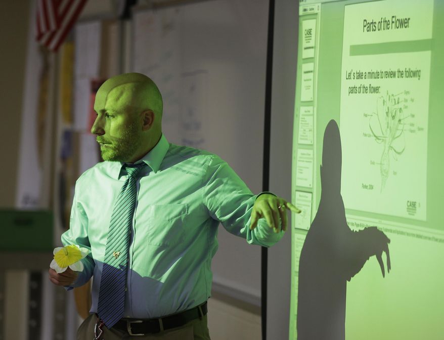 Beech Grove High School teacher Chris Kaufman talks about the parts of a flower during a Plant and Soil Science class at Beech Grove High School Wednesday, April 30, 2014, in Indianapolis. High school agriculture programs sprouting across the nation’s Corn Belt are teaching teenagers, many of them in urban environments, that careers in the field often have nothing to do with cows and plows. (AP Photo/Darron Cummings)