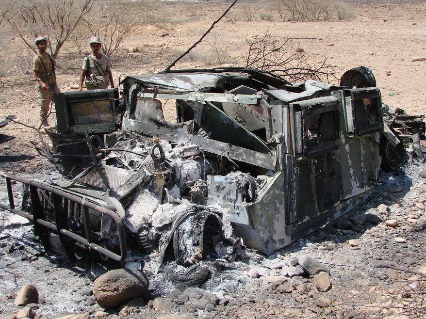 In this Thursday, May 1, 2014 photo provided by Yemen&#39;s Defense Ministry, soldiers inspect the wreckage of a vehicle destroyed during fighting with al-Qaida militants in Majala of the southern province of Abyan, Yemen. (AP Photo/Yemen&#39;s Defense Ministry)