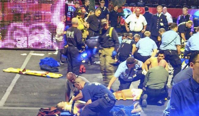 In this photo provided by Rose Viveiros, first responders work at the center ring after a platform collapsed during an aerial hair-hanging stunt at the Ringling Brothers and Barnum and Bailey Circus, Sunday, May 4, 2014, in Providence, R.I. At least nine performers were seriously injured in the fall, including a dancer below, while an unknown number of others suffered minor injuries. (AP Photo/Rose Viveiros) MANDATORY CREDIT
