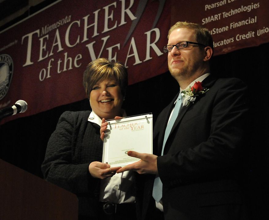 In this photo provided by Education Minnesota, Thomas Rademacher, right, is named 2014 Minnesota Teacher of the Year by Education Minnesota president Denise Specht in Bloomington, Minn., Sunday, May 4, 2014. Rademacher teaches English at FAIR School in the West Metro Education Program. (AP Photo/Education Minnesota, Janet Hostetter)