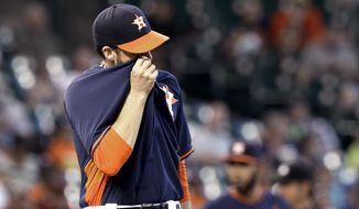 Houston Astros starting pitcher Collin McHugh wipes his face after giving up four runs to the Seattle Mariners in the third inning of a baseball game Sunday, May 4, 2014, in Houston. (AP Photo/Pat Sullivan)