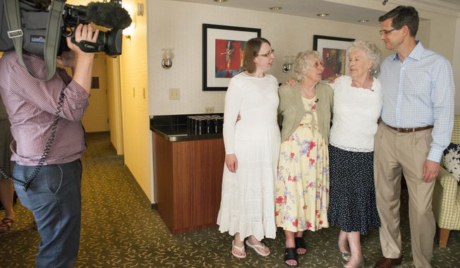A television crew from the BBC, left, records the May 1, 2014 reunion at the Fullerton Marriott of twin sisters Ann Hunt and Liz Hamel, both 78, in Fullerton, Calif. Pictured, from left, are Samantha Stacey, her mother Ann Hunt, Liz Hamel, and her son, Quinton Hamel. Hunt and Hamel are considered the world's longest-separated twins. (AP Photo/Orange County Register, Leonard Ortiz)  MANDATORY CREDIT, LEONARD ORTIZ, ORANGE COUNTY REGISTER