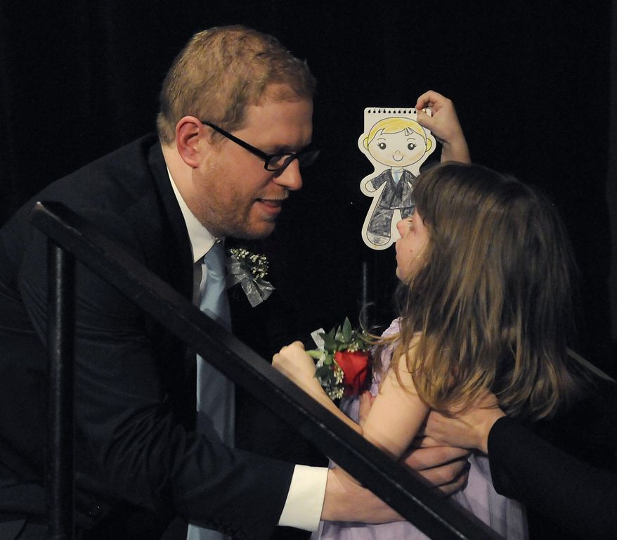In this photo provided by Education Minnesota, Thomas Rademacher is congratulated by his daughter June, 3, after being named 2014 Minnesota Teacher of the Year in Bloomington, Minn., Sunday, May 4, 2014. Rademacher teaches English at FAIR School in the West Metro Education Program. (AP Photo/Education Minnesota, Janet Hostetter)