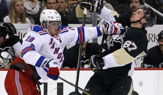New York Rangers&#39; Marc Staal (18) stiff arms Pittsburgh Penguins&#39; Sidney Crosby (87) off the puck in the second period of game 2 of a second-round NHL playoff hockey series in Pittsburgh Sunday, May 4, 2014. (AP Photo/Gene J. Puskar)