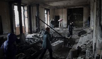 People walk inside the burnt trade union building in Odessa, Ukraine, Sunday, May 4, 2014. More than 40 people died in the riots, which some from gunshot wounds, but most in a horrific fire that tore through the trade union building late Friday. (AP Photo/Sergei Poliakov)