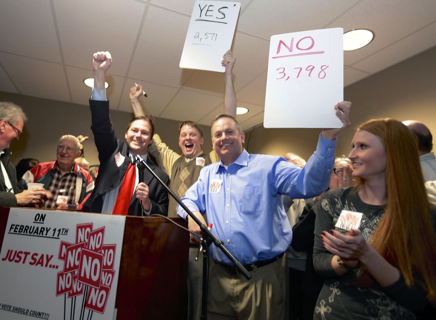 FILE - In this file photo from Feb. 11, 2014, State Sen. Charlie Jansssen of Fremont, third left, Jeremy Jensen, center, and John Wiegert, second right, celebrate in Fremont, Neb., after city voters have decided by voting no, to uphold the law designed to bar immigrants from renting homes if they don’t have legal permission to be in the U.S.  On Monday, May 5, 2014, the U.S. Supreme Court decided not to review Fremont's ordinance that bans renting homes to immigrants living in the country illegally. Supporters of the ordinance said it could open the door to similar laws elsewhere. (AP Photo/Nati Harnik, File)