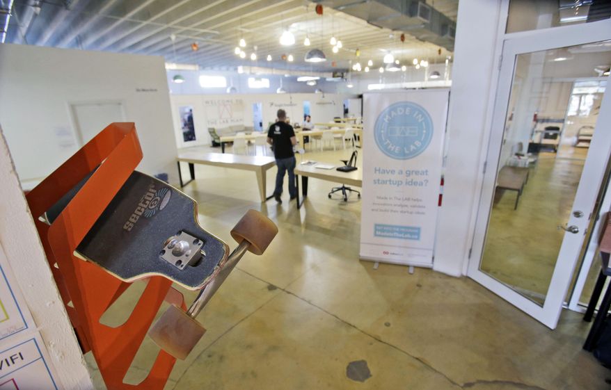 This Thursday, April 10, 2014 photo shows a skateboard rack, left, near the entrance of a new tech-focused collaborative space called The LAB Miami, in the Wynwood Arts District of Miami. Famed for its beaches, cruises and cafecitos, South Florida is now angling to become one of the nation’s next tech hot spots by leveraging its role as the gateway to Latin America and luring northern entrepreneurs with cheap living costs and lots of sun. (AP Photo/Wilfredo Lee)