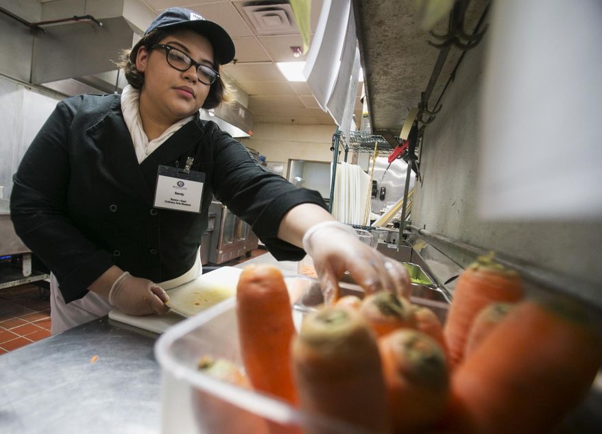In this April 15, 2014 photo, East High School senior Sandy Ocon, 17, cuts carrots and celery for soup at Hoffman House in Rockford, Ill. Ocon is one of eight juniors and seniors from across the district who have spent much of the year learning their way around the kitchen at Hoffman House. When they complete the program, students have a year of culinary education that often leads to employment at area restaurants, bakeries and grocery stores. (AP Photo/Rockford Register Star, Max Gersh)  MANDATORY CREDIT