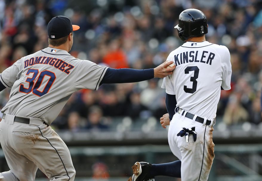 Houston Astros third baseman Matt Dominguez (30) tags Detroit Tigers' Ian Kinsler (3) out on his way to home plate in the first inning of a baseball game in Detroit Monday, May 5, 2014. (AP Photo/Paul Sancya)