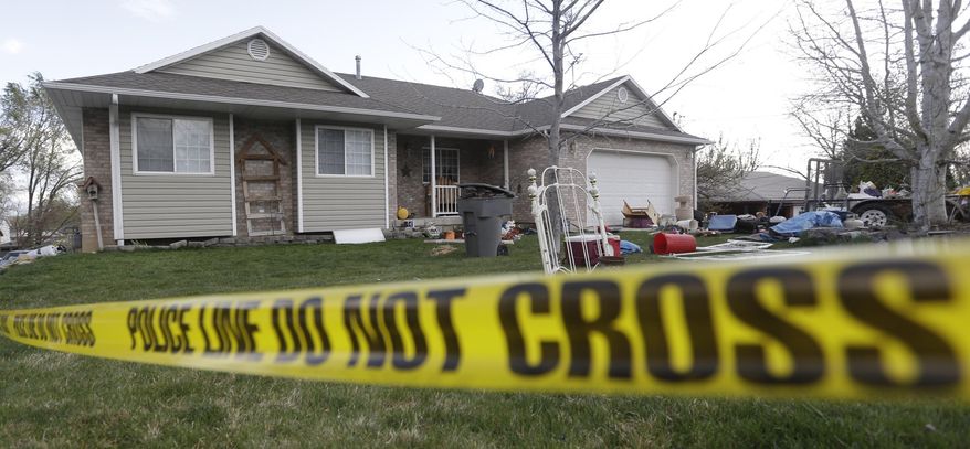 FILE - This April 13, 2014 file photo shows police tape in front of the scene where seven infant bodies were discovered and packaged in separate containers at a home in Pleasant Grove, Utah. Documents released Friday, May 2, 2014 show the body of at least one baby found in the garage of Megan Huntsman, accused of killing six of her newborns over a decade, was covered in a chemical that smelled like iodine. (AP Photo/Rick Bowmer, File)