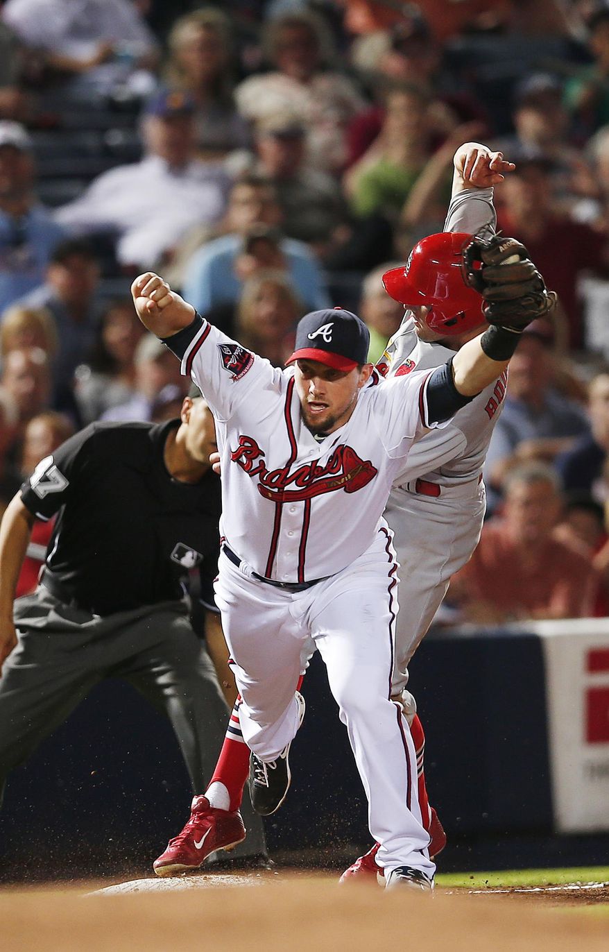 St. Louis Cardinals Peter Bourjos (8) is forced out at third base by Atlanta Braves third baseman Chris Johnson as he tries to advance on a Yadier Molina base hit in the sixth inning of a baseball game Monday, May 5, 2014, in Atlanta. (AP Photo/John Bazemore)