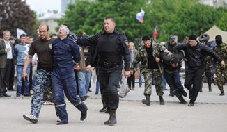 Roundup for Russia: Militants march Ukrainian state employees away from the regional administration building in Donetsk on Monday, continuing their campaign of seizing and ransacking government buildings across restive eastern Ukraine. (ASSOCIATED PRESS)
