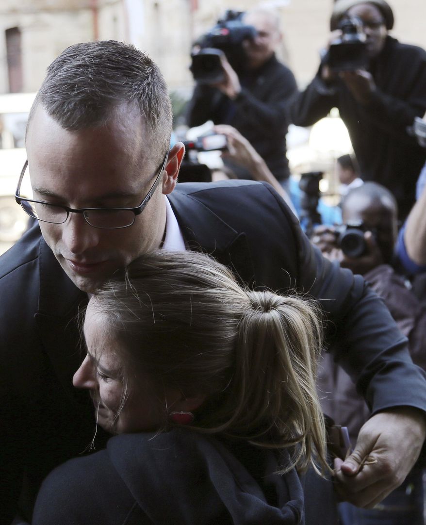 Oscar Pistorius, top, receives a hug from his fan Kayla Nolan as he arrives at the high court in Pretoria, South Africa, Monday, May 5, 2014. Pistorius' murder trial enters a critical phase Monday as his defense team attempts to recover from a faltering start and reinforce the disabled athlete's claim that he fatally shot girlfriend Reeva Steenkamp by mistake because he was overwhelmed by a long-held fear of violent crime. (AP Photo/Themba Hadebe)