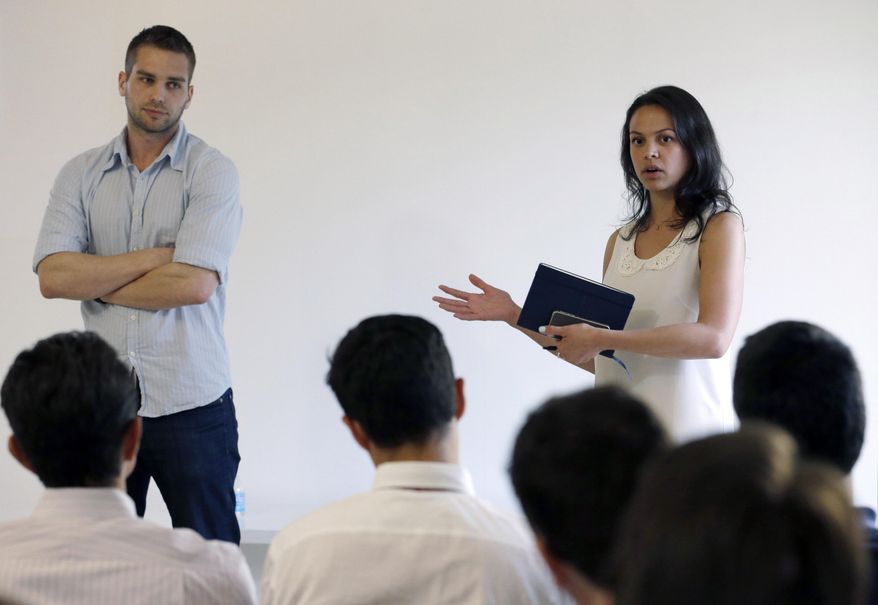 In this Thursday, April 10, 2014 photo, Elisabeth Deogracias, corporate development manager with Venture For America, right, and Mike Tarullo, vice president of corporate development, talk during a presentation at The LAB Miami in the Wynwood Arts District in Miami. Venture For America pairs college seniors and recent graduates with startup companies for a two-year fellowship. Famed for its beaches, cruises and cafecitos, South Florida is now angling to become one of the nation’s next tech hot spots by leveraging its role as the gateway to Latin America and luring northern entrepreneurs with cheap living costs and lots of sun. (AP Photo/Wilfredo Lee)