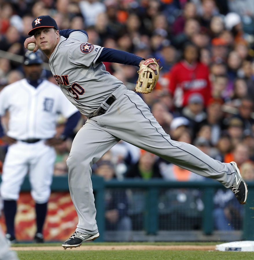 Houston Astros third baseman Matt Dominguez prepares to throw to first base on a Detroit Tigers' Torii Hunter ground ball single in the third inning of a baseball game in Detroit Monday, May 5, 2014. (AP Photo/Paul Sancya)