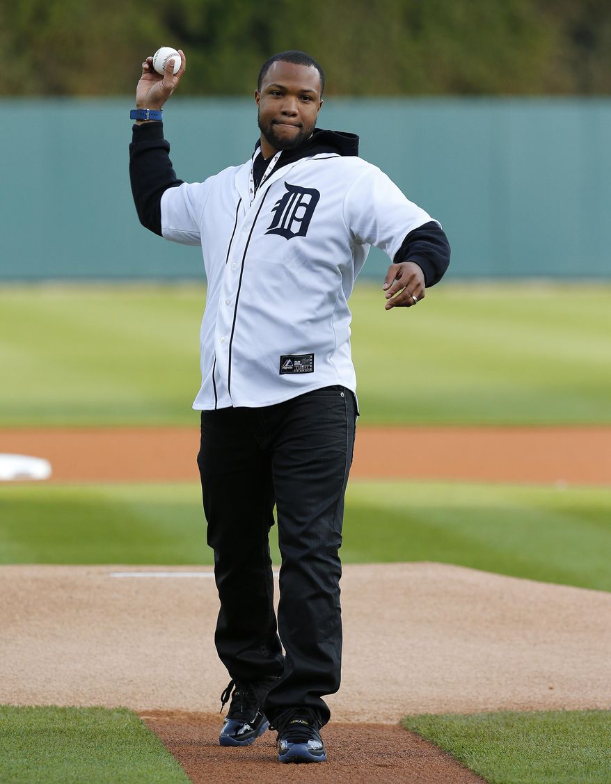 Detroit Lions safety Glover Quin throws a ceremonial pitch before the Detroit Tigers-Houston Astros baseball game in Detroit Monday, May 5, 2014. (AP Photo/Paul Sancya)
