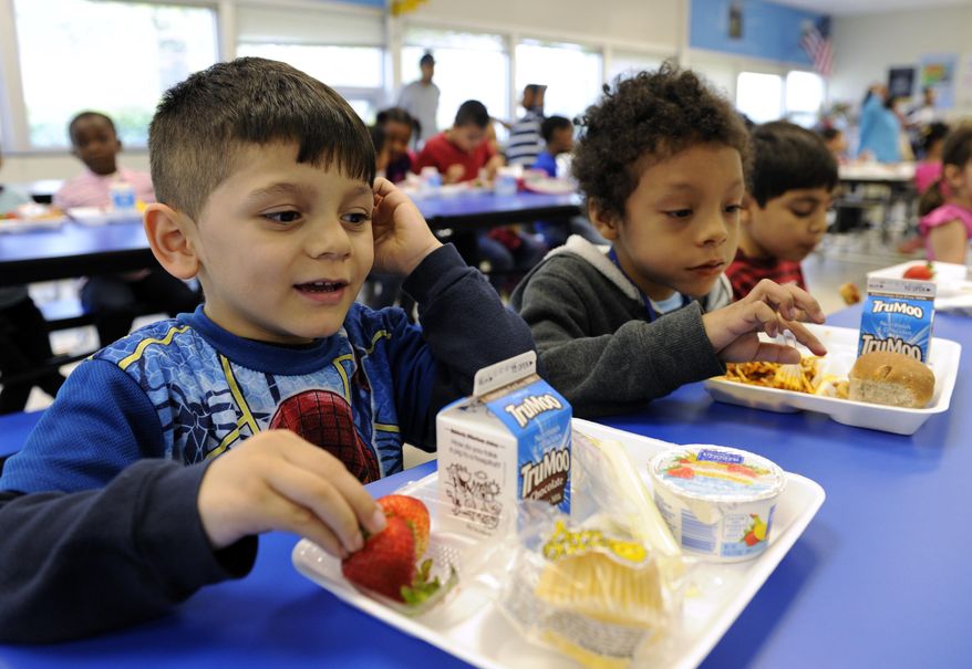 In this Tuesday, April 29, 2014 photo, Biden Arias-Romers, 5, left, and Nathaniel Cossio-Boatwright, 6, eat lunch at the Patrick Henry Elementary School in Alexandria, Va. Starting next school year, pasta and other grain products in schools will have to be whole-grain rich, or more than half whole grain. The requirement is part of a government effort to make school lunches and breakfasts healthier. (AP Photo/Susan Walsh)
