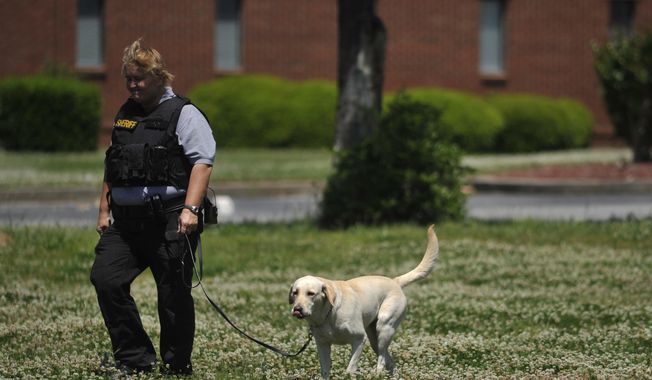 A law enforcement official searches the Paine College campus as it is on lockdown on Monday, May 5, 2014, in Augusta, Ga. The second shooting in two days at a Georgia college Monday left a student with a life-threatening gunshot wound to the head and prompted authorities to pledge to bolster security at the school. (AP Photo/The Augusta Chronicle ,Jon-Michael Sullivan)