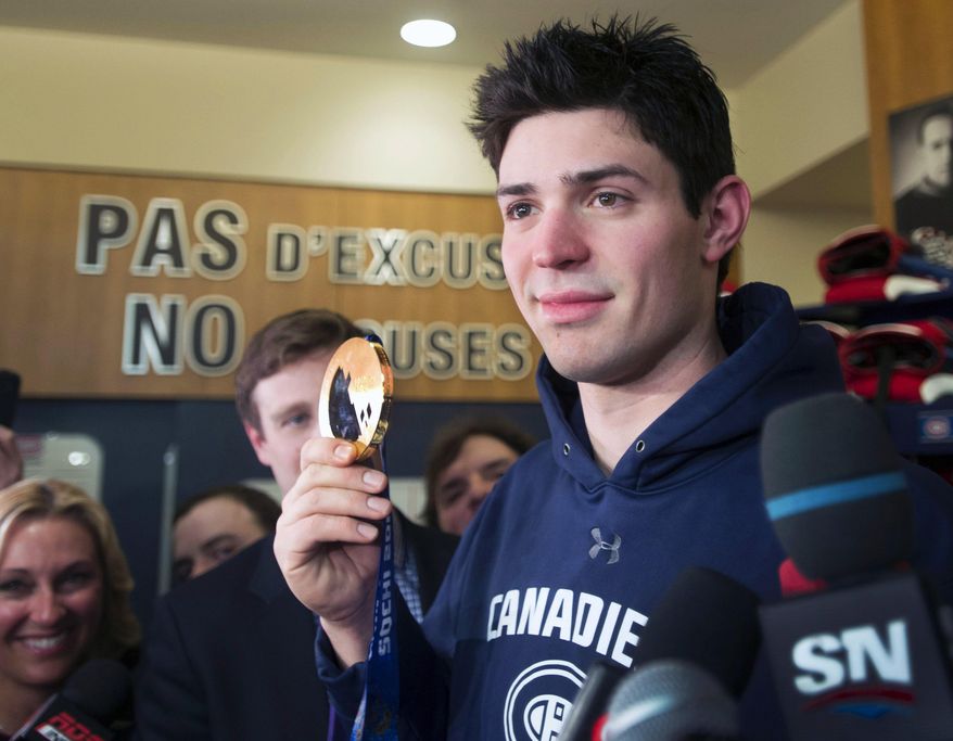 FILE - In this Feb. 24, 2014 file photo, Montreal Canadiens and Team Canada goaltender Carey Price shows his Olympic gold medal to the media in Brossard, Quebec. Price can relax _ his Labrador retrievers are back home. The Canadiens goaltender sent a message on Twitter early Monday, May 5, 2014, saying: "If anyone finds two labs running around Candiac they're mine." Candiac is a suburb south of Montreal. Local TSN radio reported that a caller who heard their report on the incident found the dogs and returned them to Price, and that the caller got an autographed stick in return. (AP Photo/The Canadian Press, Ryan Remiorz, File)