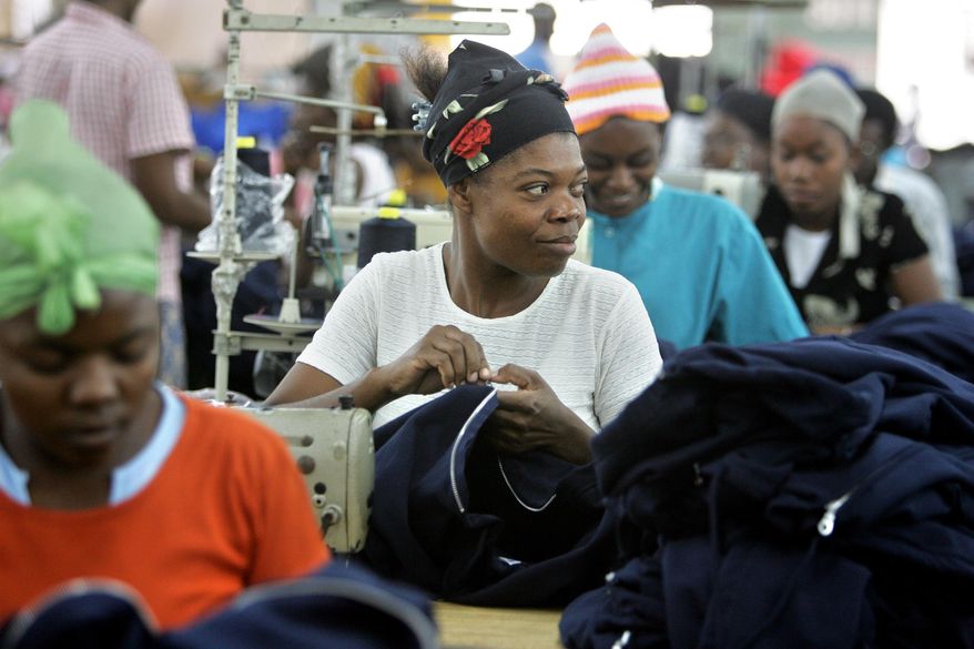 FILE - In this Jan. 31, 2006 file photo, Cylette Senatus, center, assembles a zipper on an athletic jacket, alongside dozens of other skilled seamstresses, at the AG Textile factory, in Port au Prince. Haiti raised slightly its minimum wage for the estimated 29,000 workers who sew together T-shirts and other clothing in the country's apparel factories. President Michel Martelly, his prime minister and a Cabinet member who oversees labor conditions signed the 12.5 percent increase into law. It took effect Thursday, May 1, 2014. (AP Photo/Brennan Linsley)