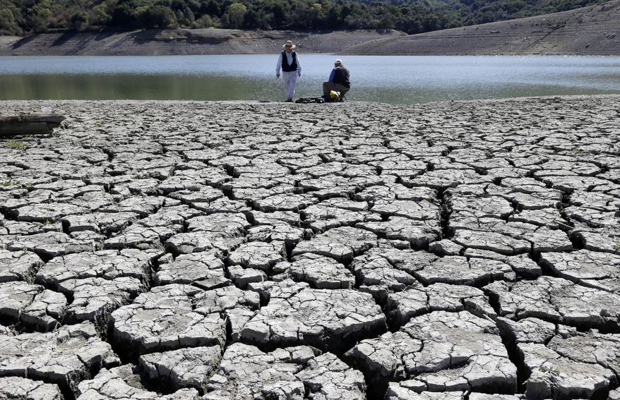 ** FILE ** This March 13, 2014, file photo shows cracks in the dry bed of the Stevens Creek Reservoir in Cupertino, Calif. The Obama administration is more certain than ever that global warming is changing Americans' daily lives and will worsen. (AP Photo/Marcio Jose Sanchez, File)