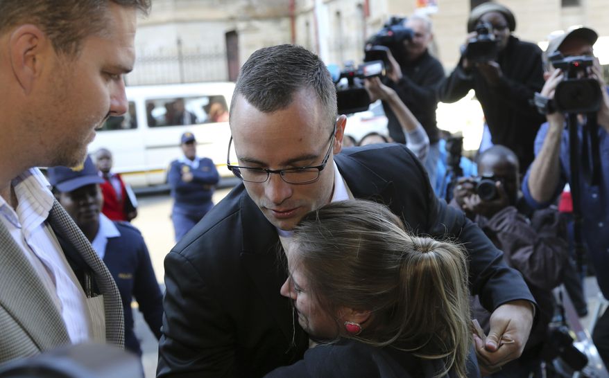 Oscar Pistorius, center top, receives a hug from his fan Kayla Nolan as he arrives at the high court in Pretoria, South Africa, Monday, May 5, 2014. Pistorius' murder trial enters a critical phase Monday as his defense team attempts to recover from a faltering start and reinforce the disabled athlete's claim that he fatally shot girlfriend Reeva Steenkamp by mistake because he was overwhelmed by a long-held fear of violent crime. (AP Photo/Themba Hadebe)