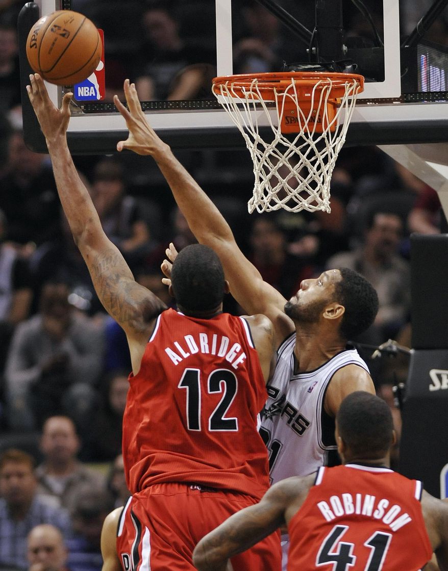 FILE - In this March 12, 2014 file photo, San Antonio Spurs forward Tim Duncan, right rear, defends Portland Trailblazers forward LaMarcus Aldridge, left, as Portland Trailblazers forward Thomas Robinson looks on, during the first half of an NBA basketball game in San Antonio. The Western Conference semifinal battle between San Antonio and Portland begins Tuesday, May 6, 2014, in San Antonio. (AP Photo/Darren Abate, File)