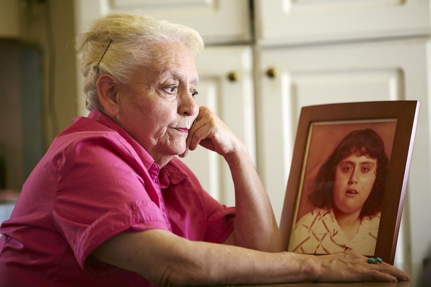 In this Friday, May 2, 2014 photo, Rosemary Verdugo poses with a photo of her late daughter, Mary Ann Verdugo seen at 17 years-old, at her home in Maywood, Calif. Verdugo, whose mentally challenged daughter died at age 49-year-old of cardiac arrest in a Southern California Target retail store. Verdugo filed a wrongful death lawsuit, arguing that Target should have had a defibrillator on hand to jolt her daughter’s heart back to beating. Some 300,000 Americans suffer cardiac arrest each year and defibrillators increase the survival rate of victims from 8 percent to 30 percent, according to the American Heart Association. (AP Photo/Damian Dovarganes)