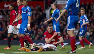 Manchester United&#39;s Phil Jones, bottom centre, sits injured on the pitch prior to being substituted, during his team&#39;s English Premier League soccer match against Hull City,  at Old Trafford Stadium, Manchester, England, Tuesday May 6, 2014. (AP Photo/Jon Super)