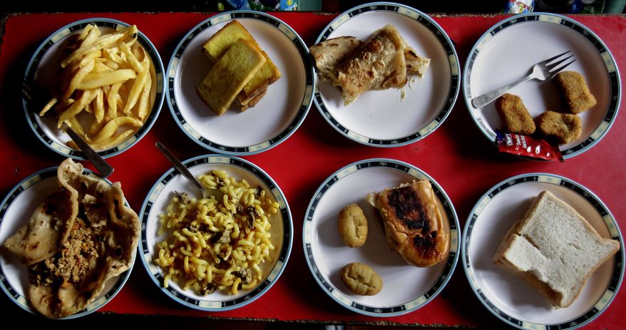 Assorted lunch plates are arranged at a table for students at the Bahria Foundation school in Rawalpindi, Pakistan, Tuesday, May 6, 2014. Most of the kids seen there have home cooked food for lunch. Principal Syeda Arifa Mohsin says the school tries to dissuade parents from fixing junk food for their children. “If we discover that a child has junk food, we ask his or her parents to please make a little effort for their child’s health,” Mohsin says. (AP Photo/Anjum Naveed)