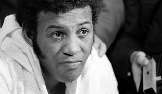 FILE - In this Feb. 16, 1970, file photo, a defeated Jimmy Ellis as shown in his dressing room after losing heavyweight title bout  to Joe Frazier at New York&#x27;s Madison Square Garden. Ellis, a former heavyweight boxing champion who trained with fellow Louisville fighter Muhammad Ali and squared off against some of his era&#x27;s best fighters, has died in his hometown Tuesday, May 6, 2014. He was 74. Ellis&#x27; brother, Jerry, said the ex-champion died at a Louisville hospital Tuesday after suffering from Alzheimer&#x27;s disease in recent years. (AP Photo/File)
