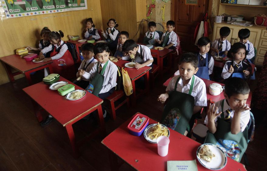 Students eat their lunch at the Bahria Foundation school in Rawalpindi, Pakistan, Tuesday, May 6, 2014. Most of the children at the school have home cooked food for lunch, which contain eggs, chicken nuggets, bread, rice or noodles. Some have vegetables, minced mutton or beef prepared and cooked at home the night before. Principal Syeda Arifa Mohsin says the school tries to dissuade parents from fixing junk food for their children. (AP Photo/Anjum Naveed)