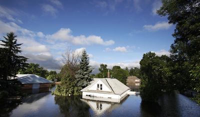 FILE - In this June 27, 2011 file photo, floodwaters from the Souris River surround homes near Minot State University in Minot, N.D. Global warming is rapidly turning America the beautiful into America the stormy, sneezy and dangerous, according to the National Climate Assessment report released Tuesday, May 6, 2014. (AP Photo/Charles Rex Arbogast)