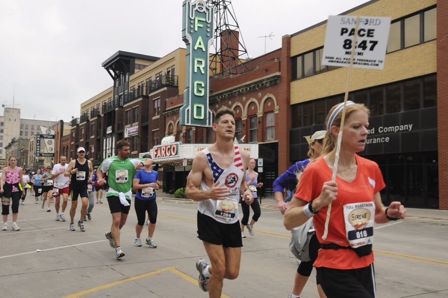 FILE - In this May 21, 2011 file photo provided by the Department of Defense, Maj. George Kraehe, of Albequerque, N.M., center, and other runners pass the Fargo Theater during a marathon in Fargo, N.D. The Fargo Marathon, being run Saturday, May, 10, 2014, is celebrating its 10th anniversary this year with more than 23,000 participants. (AP Photo/Department of Defense, Senior Master Sgt. David H. Lipp, File)