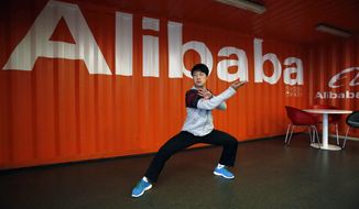 FILE - In this file photo taken Tuesday March 26, 2013, a worker performs shadow boxing during an open day at the Alibaba Group office in Hangzhou in east China&#39;s Zhejiang province. Alibaba Group is aiming to raise $1 billion in a long-awaited IPO likely to have ripple effects across the Internet. The Tuesday, May 6, 2014 filing sets the stage for the technology industry&#39;s biggest initial public offering since short messaging service Twitter and its early investors collected $1.8 billion in its stock market debut last fall.  (AP Photo) CHINA OUT