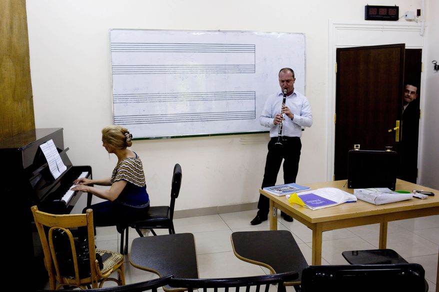 In this Sunday, May 4, 2014 photo, musicians practice at an art school which adjoins the Damascus Opera House in Damascus, Syria. Two students were killed and five others were wounded when a mortar landed outside the Opera building in April 2014. (AP Photo/Dusan Vranic)
